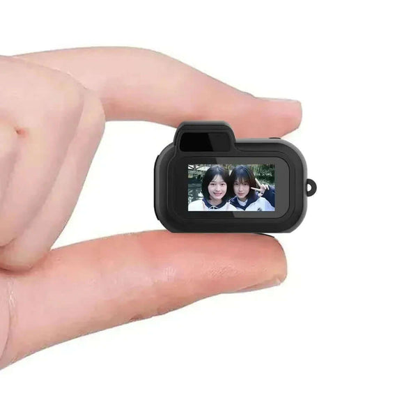 Mini SLR 1080P pocket camera held between two fingers, showcasing its compact design and built-in display.